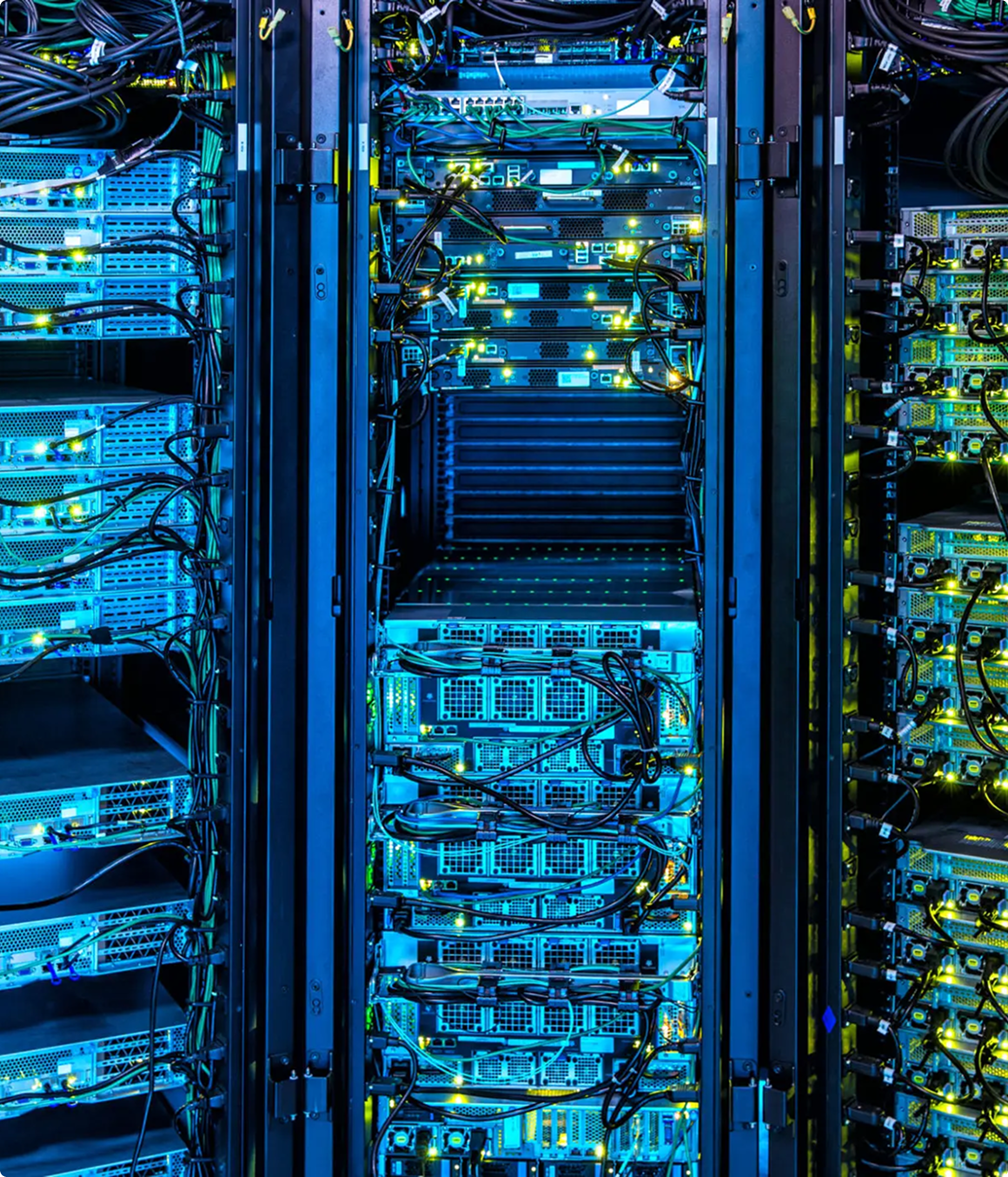 Rows of computer servers with illuminated indicator lights and network cables in a blue-lit data center environment.